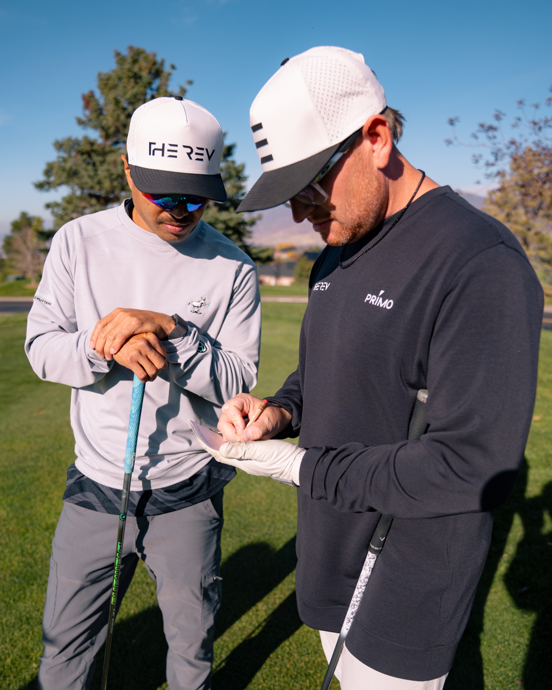REV Tour players checking the scorecard together